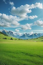 Panoramic Natural Landscape With Green Grass Field, Blue Sky With Clouds And Mountains In The Background