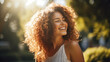 © Studio Nova - Beautiful young woman with curly hair smiling in nature on a sunny day.