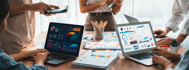 Fototapete - Panorama shot analyst team utilizing BI Fintech to analyze financial report with laptop. Businesspeople analyzing BI power dashboard displayed on laptop screen for business insight. Scrutinize