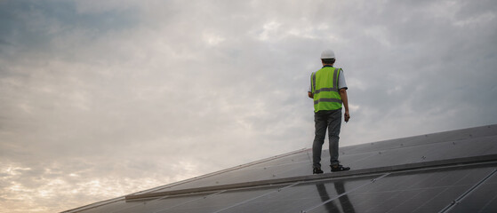 Wall Mural - a service engineer checks a solar cell that is mounted on the roof to see if there is a damaged comp