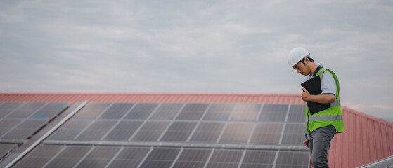 Wall Mural - a service engineer checks a solar cell that is mounted on the roof to see if there is a damaged comp
