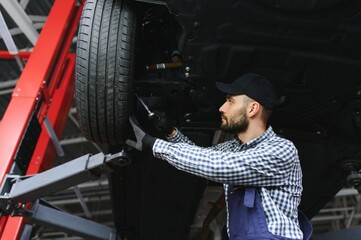 Leinwandbilder - Auto mechanic working at auto repair shop