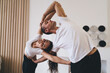 © BullRun - Happy diverse couple doing acro yoga in studio