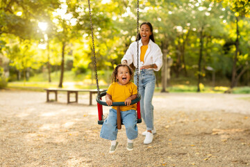 Wall Mural - Asian Mom Riding Baby Daughter On Swing At Playground Outside