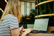 © Lazy_Bear - Woman using laptop in coworking with green plants. Female freelancer typing on laptop keyboard. Online work in cafe