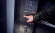 Man, hands and pressing button in elevator for transportation in building, floor or number indoors. Hand of male person selecting control on machine or lift for level up or down on touch panel