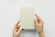 © Iryna_B - female hands holding a blank postcard on a gray background