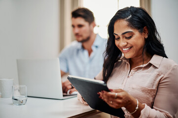 Fototapete - Facilitating a meeting with awesome functionality. Shot of a young businesswoman using a digital tablet during a meeting in a modern office.