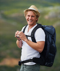 Wall Mural - The view from up here is sublime. Shot of a young man with binoculars hiking outdoors.