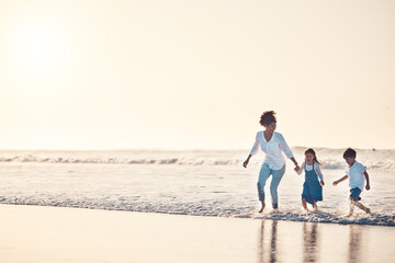 Playing, mother and children at beach on a fun family vacation, holiday or nature adventure at sunset. Young boy and girl holding hands with a woman outdoor for fun energy, happiness and banner space
