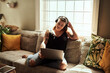 © Malambo C/peopleimages.com - Sundays are for marathon movie streaming sessions. Shot of a young woman using a laptop and headphones on the sofa at home.