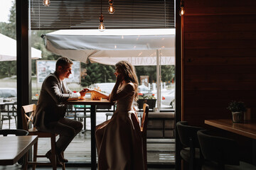 Side view portrait of a laughing European couple enjoying a date in a cafe. A couple in love, a man proposes to his beloved