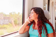© Sangiao_Photography - Train traveler. Hispanic mid-adult woman looking through the window on holiday lifestyle vacation