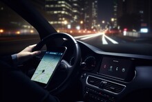 While Driving In The City At Night, A Man Uses A GPS App On His Smartphone To Search For A Destination Or Address.




