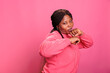 © DC Studio - Aggressive model clenching fists and showing raised knuckles on camera in studio, feeling angry and doing air punches. Furious african american woman preparing to fight doing combat demonstration.