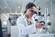 Leinwandbild Motiv Science, microscope and innovation with a woman in a laboratory for medical research or experiment. Healthcare, medicine and a young indian engineer working in a lab for pharmaceutical development