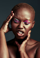 Poster - Looking flawless in color. Cropped shot of a beautiful woman wearing colorful eyeshadow while posing against a grey background.