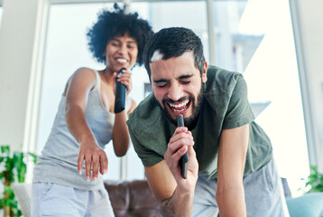 he knows that i always have his back. cropped shot of a couple having a sing along at home.