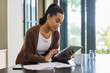 © CineLens/peopleimages.com - Technology, woman with tablet and documents paying her bills online at her home. Payment or banking, budget or internet connectivity and female person with paper on kitchen counter of her house