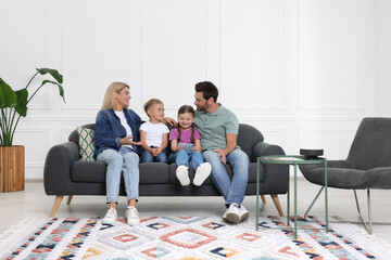 Canvas Print - Happy family with smartphone spending time together on sofa at home