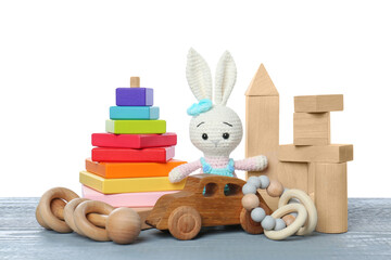 Wall Mural - Different children's toys on grey wooden table against white background