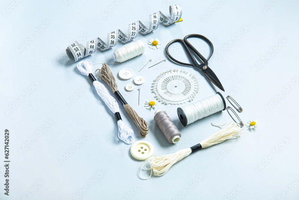 Set of different embroidery supplies on grey background
