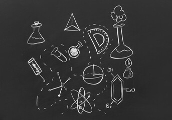 Different drawn physical and chemical symbols on black chalkboard