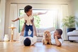 © Irshaad Majal/peopleimages.com - Dad, mother and home playing airplane together with happiness and puppy with smile. House, family and support of a mom, father and young child with dog and animal in living room having fun on floor