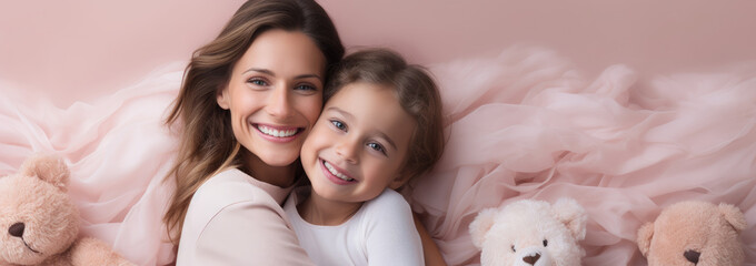 Wall Mural - Portrait of a Caucasian girl and mother on pink rose gold beige with bear doll background. World Mother's Day concept