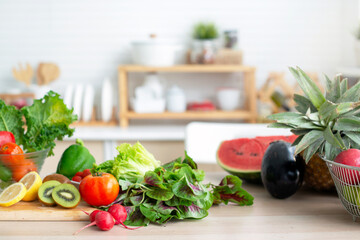 Fresh fruits and vegetables on wooden table in bright white kitchen, healthy lifestyle concept