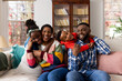 © Wavebreak Media - Portrait of happy african american couple with son and daughter embracing on sofa at home