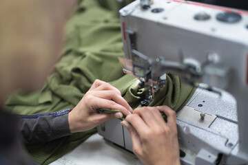 Wall Mural - workers in an industrial garment factory sew clothes on sewing machine