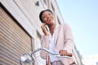 Phone call, happy and black woman employee on bicycle to commute or travel to work talking to a at contact. Street, city and young worker laughing speaking on mobile conversation in an urban town
