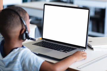 Poster - Rear view of african american boy having a video call on laptop with copy space at home