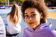 © oneinchpunch - Multiracial group of young friends bonding outdoors, portrait of beautiful black hispanic young female looking at camera smiling