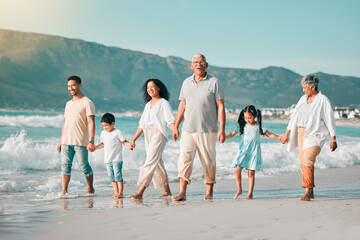 Wall Mural - Holding hands, family is walking on beach and ocean, generations and bonding in nature with waves. Grandparents, parents and kids, people outdoor and travel with trust and love on Mexican holiday