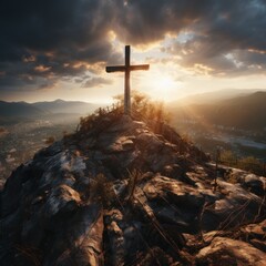 Christian cross on the top of a mountain with sunbeams through the clouds