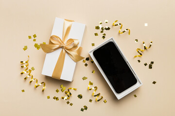 Opened gift box with gold ribbon and smartphone on color background, top view. Blank open box packaging mockup , Template for your design - branding mockup