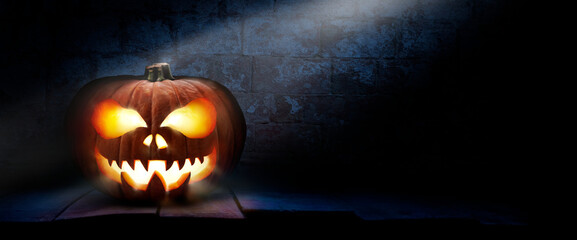 Wall Mural - the spooky haunted evil glowing eyes of jack o' lanterns, halloween pumpkin, on the left of a wooden