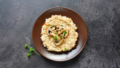 Wall Mural - A dish of Italian cuisine - risotto from rice and mushrooms in a brown plate on a black slate background. Top view. Flat lay. Copy space.