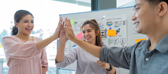 Wall Mural - group of designer cheerful giving high five on the success of website design and application on mobi