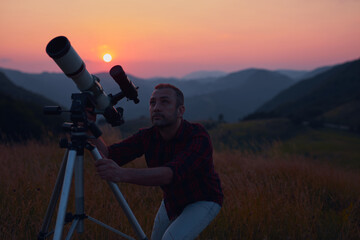 Wall Mural - astronomer looking at the skies with a telescope.