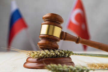 Hammer, wheat, barley ears and flags of countries on the table, a concept on the topic of a grain deal between Russia and Turkey