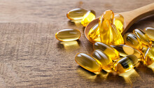Fish Oil Capsules On Wooden Background, Vitamin D Supplement