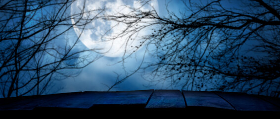 Wall Mural - A wooden bench product display on a scary halloween night with a blurry background of a night sky and moon to isolated foreground objects.