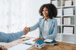 © Jirapong - The bank's Female African american Mortgage Officers shake hands with customers to congratulate them after signing a housing investment loan agreement