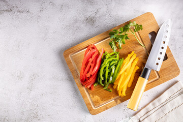 Colorful bell peppers sliced on cutting board.