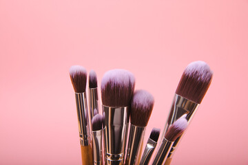 Wall Mural - Cosmetic makeup brush on a pink background. Cosmetic product for make-up. Creative and beauty fashion concept. Fashion. Collection of cosmetic makeup brushes, top view, banner.Place for text. MOCAP.