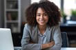 © InputUX - Confident African American woman smiling proudly at her office desk, facing the camera with a computer nearby, generative ai