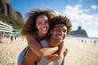 © Creative Clicks - Portrait of a young Brazilian black couple in a piggyback position, having fun at the beach.